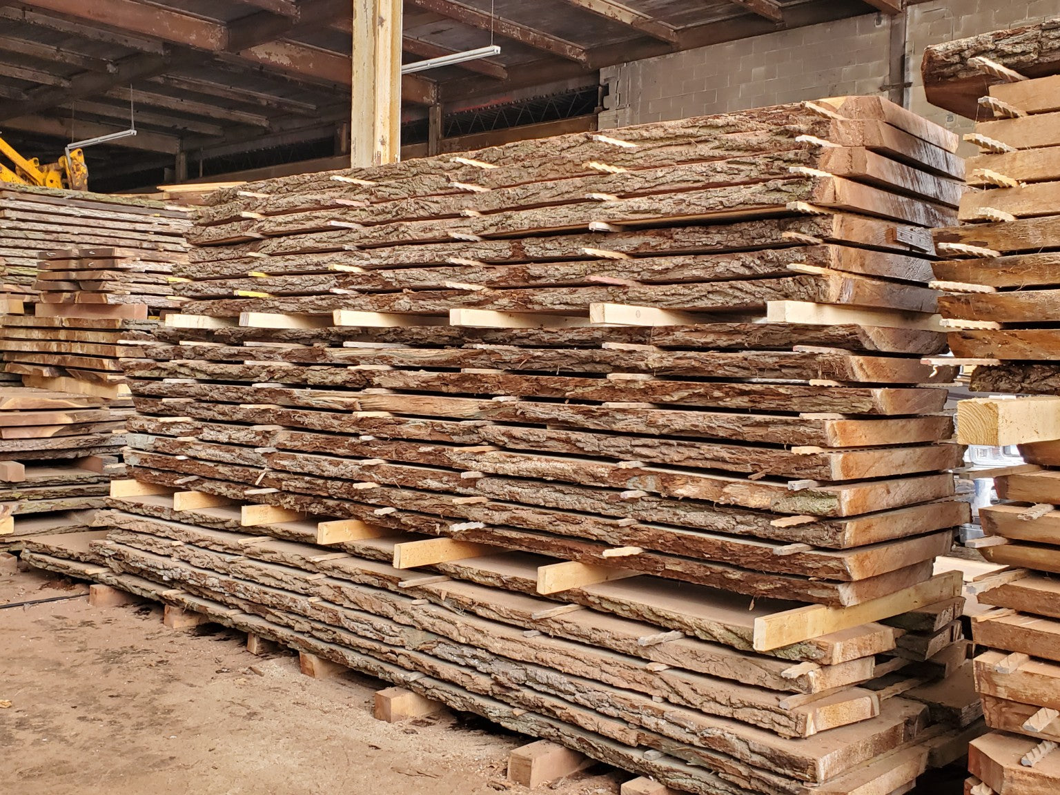 Stacks of rough-cut walnut slabs air-drying in Beaver Hardwood’s private material inventory.